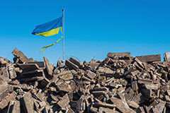 Ukranian flag over rubble
