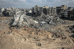 People wander through the devastated area near the al-Maqoussi towers in the aftermath of an Israeli bombardment in Gaza City on Feb. 3