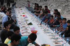 Syrian civilians eat an Iftar meal provided by a group of volunteers in a damaged neighborhood of Atarib, Aleppo countryside,
