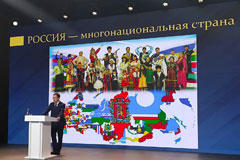 Vladimir Medinsky gives a lecture on the 300th anniversary of the Russian Empire.  Text on the screen reads “Russia is a  multiethnic country.”