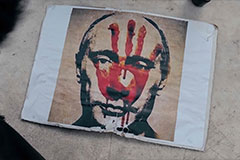 Graphic picture of Putin with red handprint on face