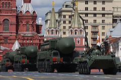 Tanks carrying large weapons during a Russian military parade.
