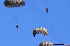 US, British, and Latvian soldiers parachute out of a C-130 Hercules aircraft as part of a joint airborne training exercise at the Camp Grayling Joint Maneuver Training Center in Michigan during Northern Strike 21, aimed at building readiness and interoperability with other units and multinational partners. Photo by Army Staff Sgt. Tegan Kucera/US Defense Dept.