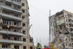 rescuers search for survivors at an apartment block hit by Russian rockets during a massive missile attack on Dnipro
