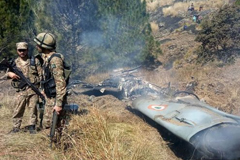 Pakistani soldiers stand by what Pakistan says is wreckage from a downed Indian jet 