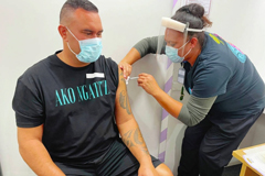 Aaron Te Moananua, left, receives a dose of the Pfizer COVID-19 vaccine in Auckland, New Zealand. New Zealand has opened its first large vaccination clinic as it scales up efforts to protect people from the coronavirus. [New Zealand Ministry of Health via AP]