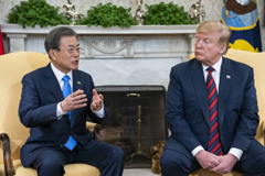 South Korean President Moon Jae-in speaks with U.S. President Donald Trump in the Oval Office of the White House on Thursday. | BLOOMBERG