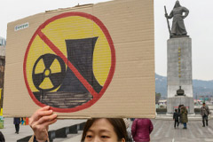 A South Korean environmental activist holds a banner during the anti-nuclear and anti-fossil energy rally at Gwanghwamun Square in central Seoul on 11 March 11, 2024
