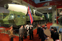 In this photo provided by the North Korean government, North Korean leader Kim Jong Un, center, speaks in front of what the North says is an intercontinental ballistic missile displayed at an exhibition of weapons systems in Pyongyang on Oct. 11, 2021. (AP/Korean Central News Agency/Korea News Service via AP)