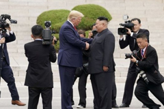 Donald Trump and Kim Jong-un shaking hands at the DMZ in June 