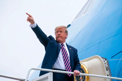 President Trump pointing his finger in a salute boarding air force one plane
