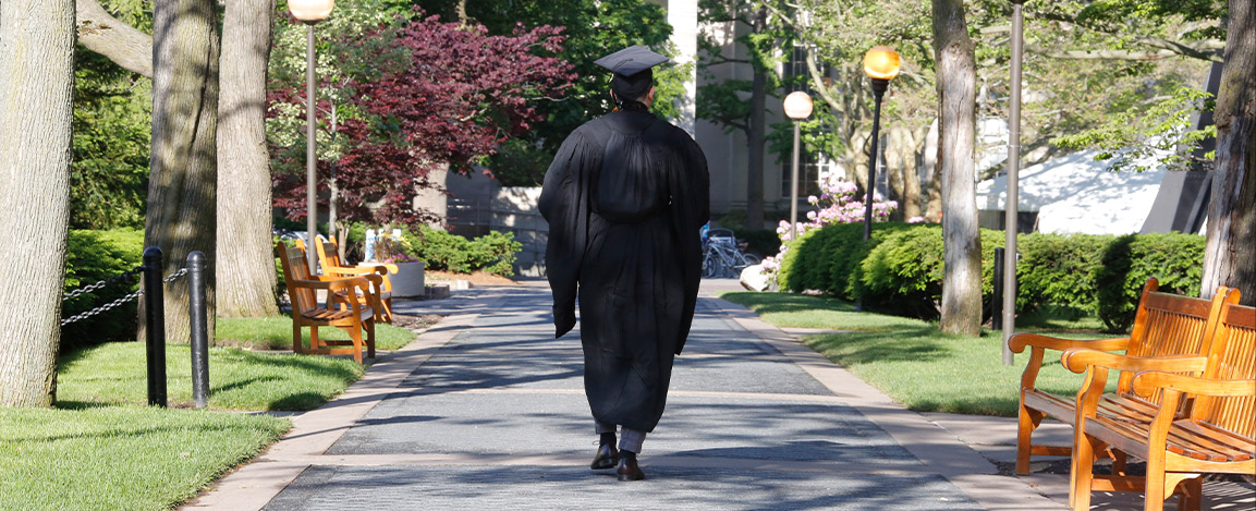 Graduate walking away from campus