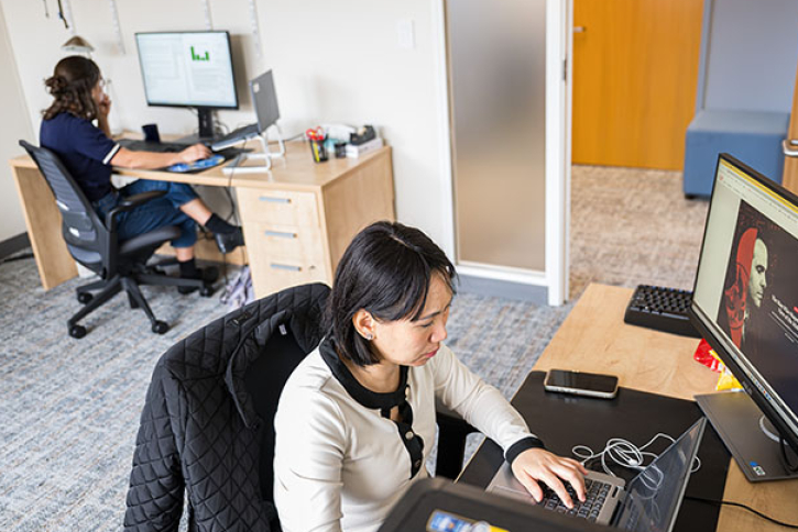 Two CIS researchers on their computers in their office